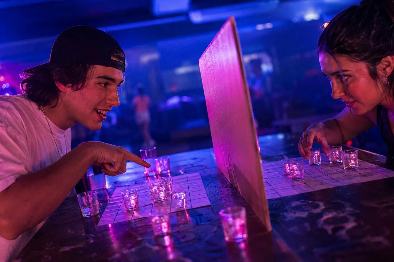 Dos personas jugando Batalla naval con shots usando caballitos