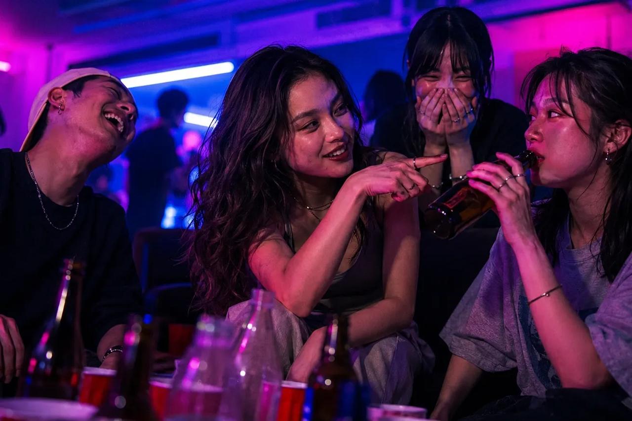 お酒を片手にパーティーで「真実か飲むか」をプレイする友達グループ